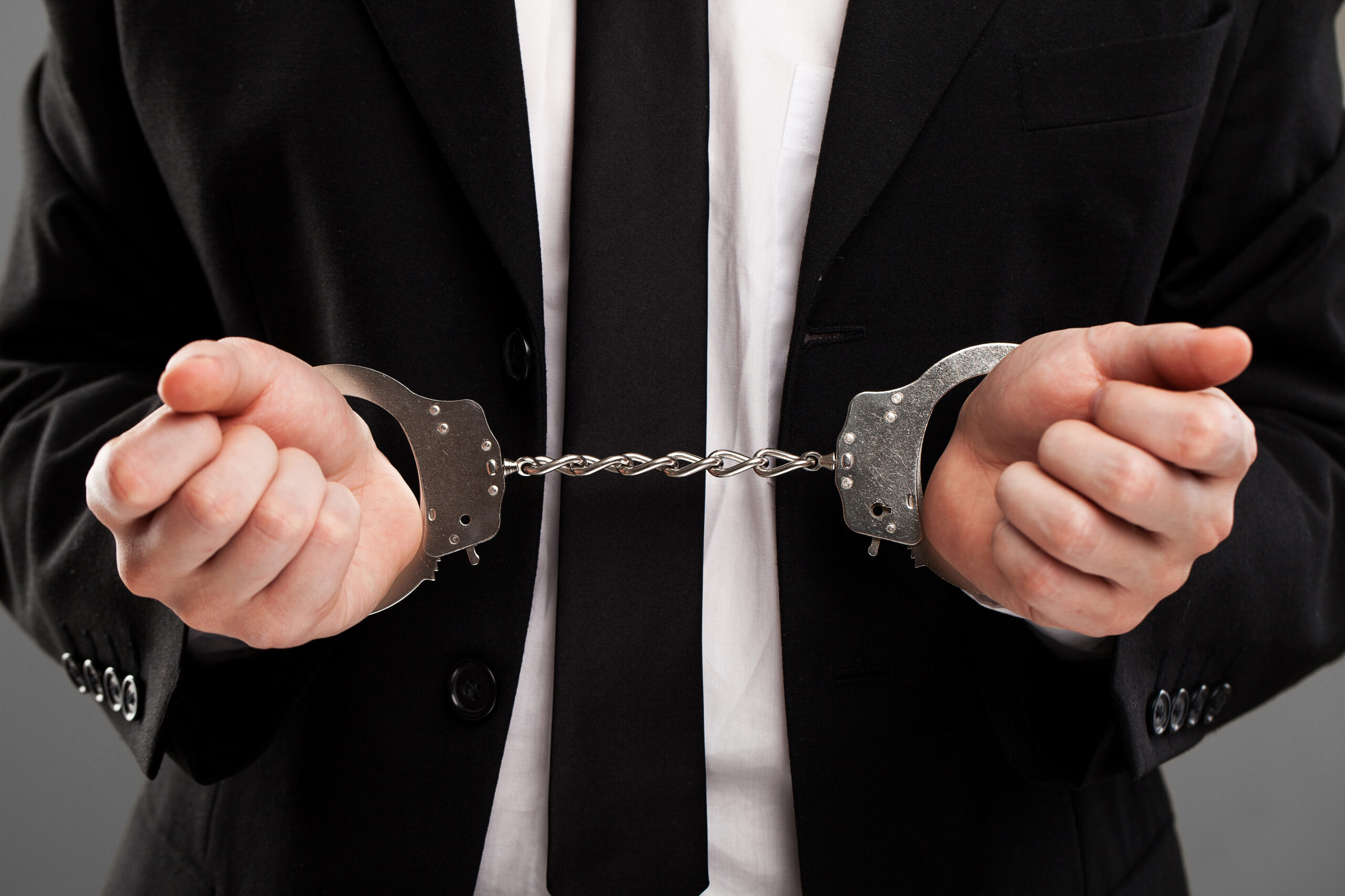 Businessman in suit with closed manacles on his hands